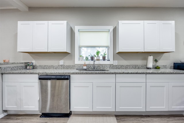 kitchen with white cabinets, light stone countertops, dishwasher, and sink