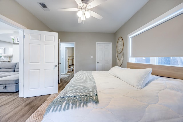 bedroom with multiple windows, ceiling fan, and hardwood / wood-style floors