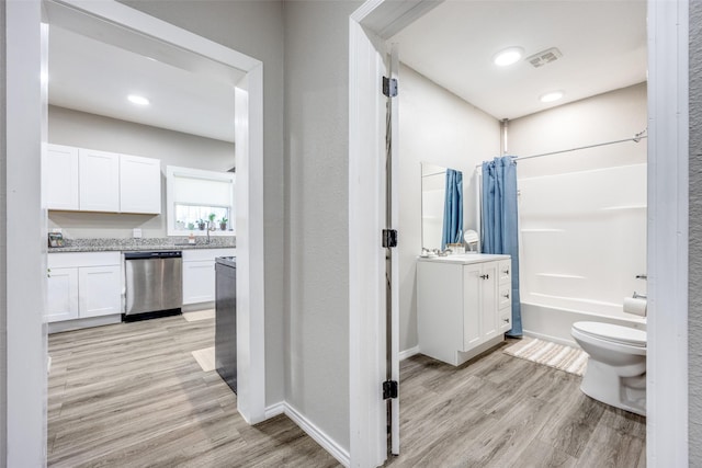 full bathroom with shower / bath combination with curtain, toilet, vanity, and hardwood / wood-style flooring