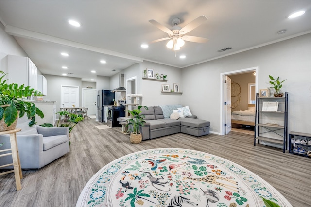 living room with crown molding, ceiling fan, and light hardwood / wood-style flooring