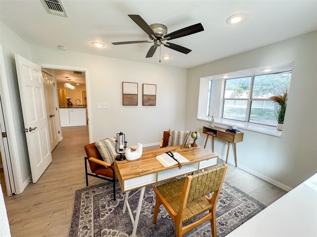 office area featuring ceiling fan, light hardwood / wood-style flooring, and sink