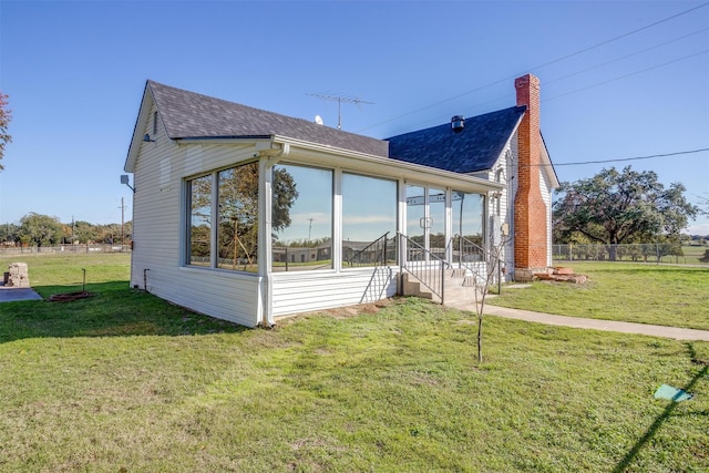 view of property exterior with a sunroom and a yard