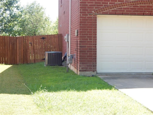 view of side of home featuring a garage, central AC, and a lawn