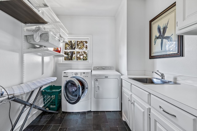 laundry room featuring cabinets, washer and clothes dryer, and sink