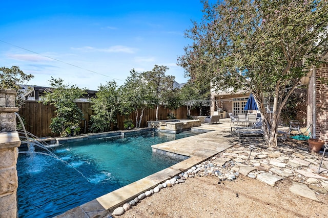 view of swimming pool with pool water feature, a patio area, and an in ground hot tub