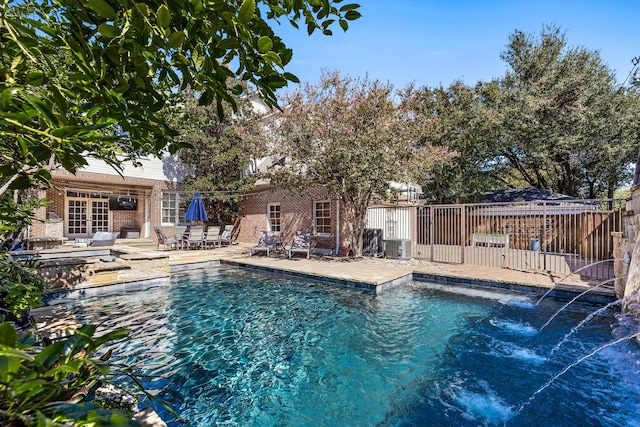 view of swimming pool featuring french doors, pool water feature, and a patio area