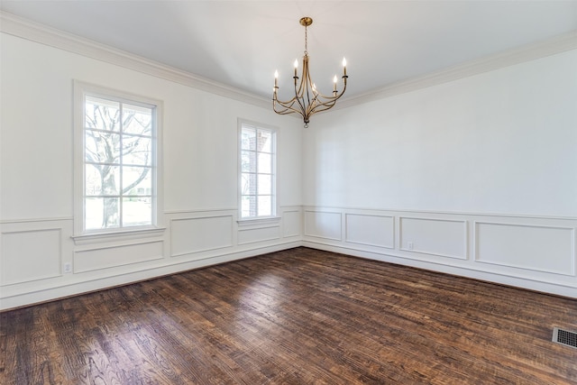 empty room with a chandelier, dark hardwood / wood-style floors, and ornamental molding