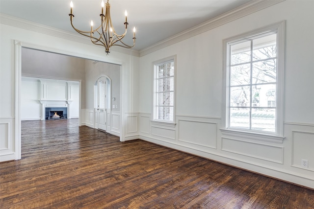 unfurnished dining area with dark hardwood / wood-style flooring, an inviting chandelier, a wealth of natural light, and ornamental molding