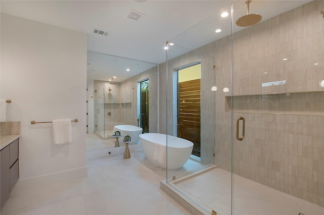 bathroom featuring tile patterned flooring, vanity, and shower with separate bathtub