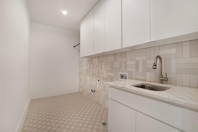 washroom featuring hookup for an electric dryer, hookup for a washing machine, cabinets, and sink