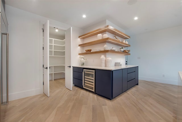 bar with wine cooler and light wood-type flooring