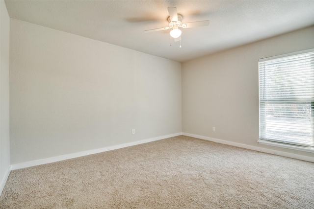 carpeted empty room featuring ceiling fan