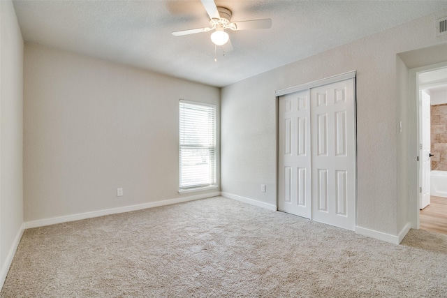 unfurnished bedroom featuring light carpet, a closet, and ceiling fan