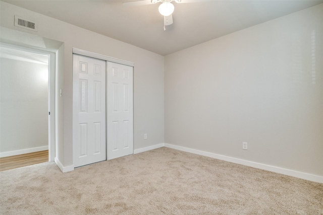 unfurnished bedroom featuring a closet, ceiling fan, and light colored carpet