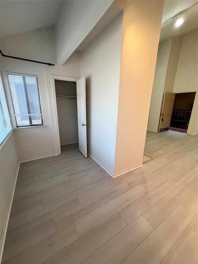 unfurnished bedroom featuring light hardwood / wood-style floors and vaulted ceiling