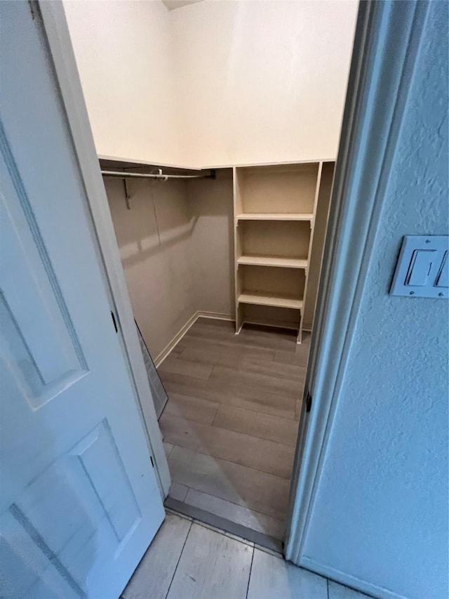 walk in closet with hardwood / wood-style floors