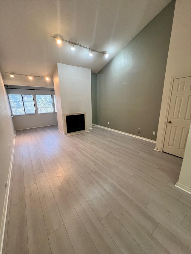 unfurnished living room with light wood-type flooring and vaulted ceiling