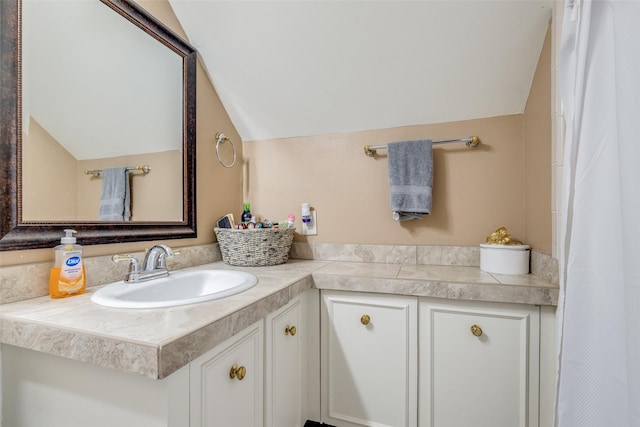 bathroom with lofted ceiling and vanity