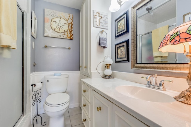 bathroom with an enclosed shower, vanity, toilet, and tile patterned flooring