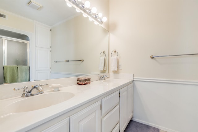 bathroom with crown molding, a shower with door, and vanity