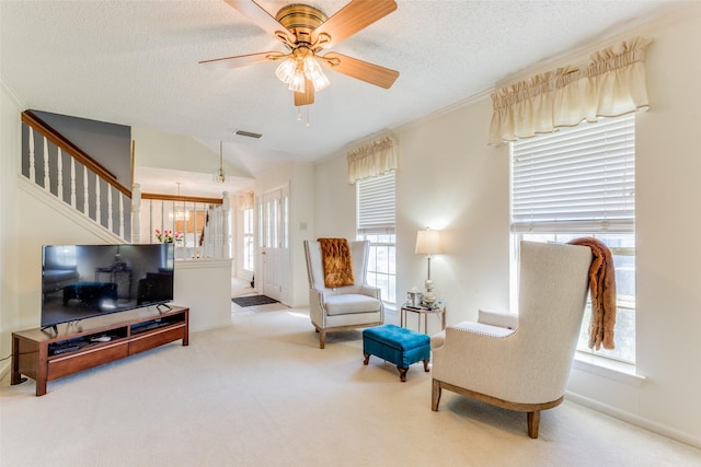 sitting room featuring light carpet, ceiling fan, and a textured ceiling