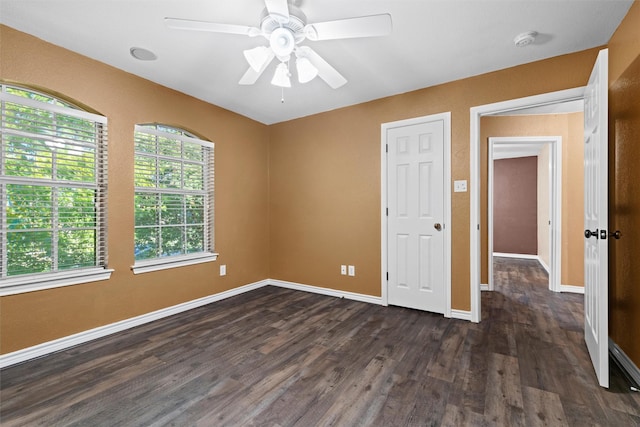 unfurnished bedroom with dark wood finished floors, baseboards, and ceiling fan