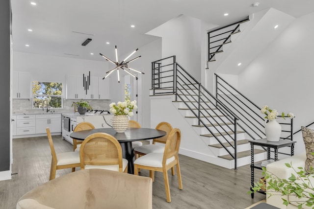 dining area featuring light wood-type flooring, an inviting chandelier, and sink