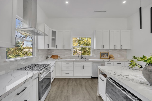 kitchen featuring island range hood, white cabinets, and appliances with stainless steel finishes