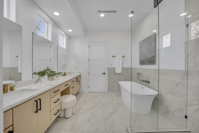 bathroom featuring vanity, separate shower and tub, and tile walls