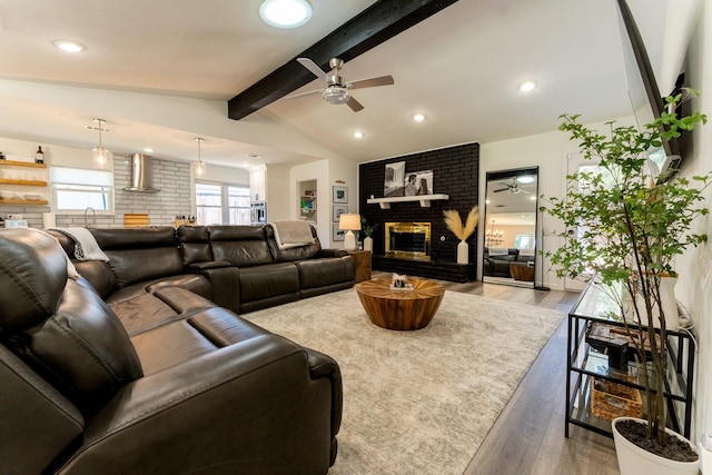 living room with a fireplace, wood-type flooring, and vaulted ceiling with beams