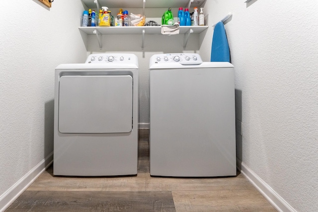 laundry room featuring hardwood / wood-style floors and washing machine and clothes dryer