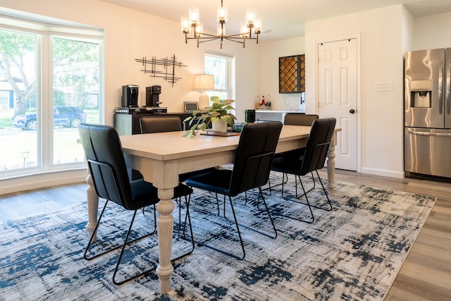 dining space featuring hardwood / wood-style floors and an inviting chandelier