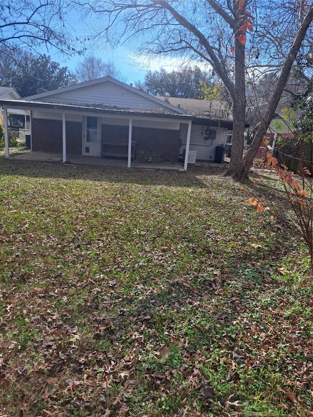 back of property featuring a patio area and a yard