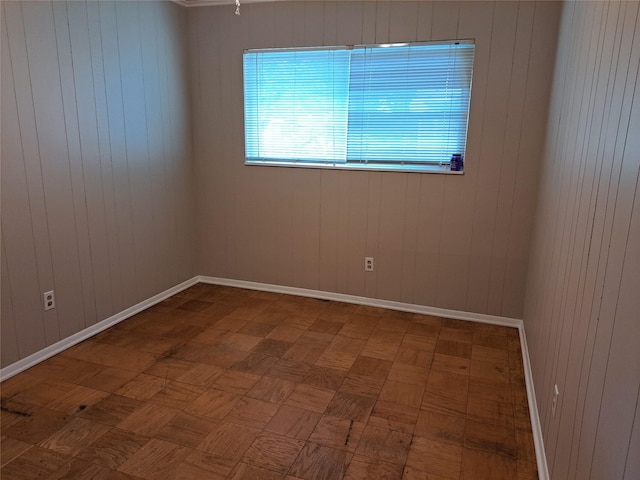 empty room with parquet flooring and wooden walls