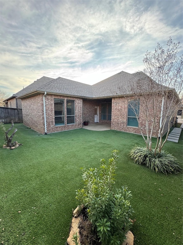 rear view of house featuring a yard and a patio area