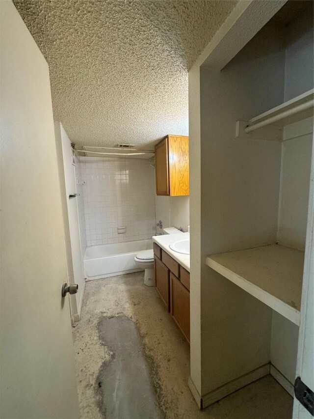 6108 Abrams Rd Unit 127, Dallas, TX 75231 - full bathroom with vanity, a textured ceiling, concrete floors, toilet, and tiled shower / bath