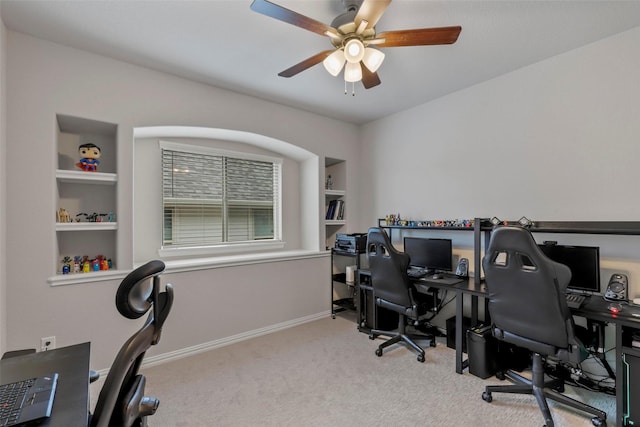 carpeted home office featuring ceiling fan and built in features