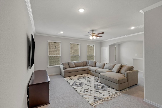 carpeted living room with crown molding and ceiling fan