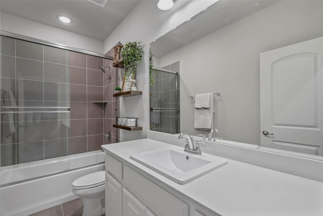 full bathroom featuring tile patterned flooring, vanity, toilet, and bath / shower combo with glass door