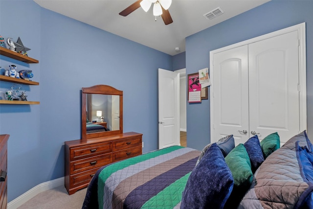 bedroom featuring light colored carpet, a closet, and ceiling fan