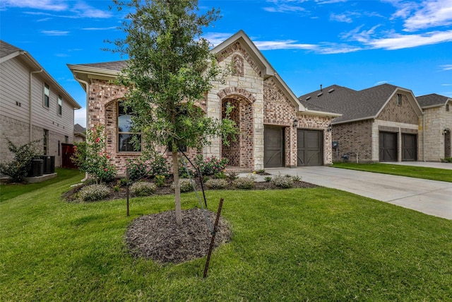 view of front of home featuring cooling unit, a garage, and a front lawn