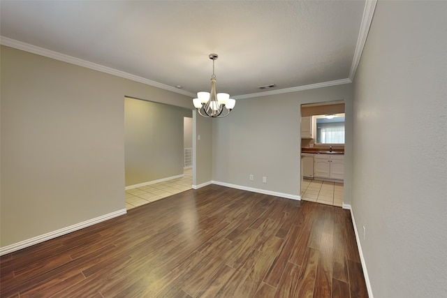 unfurnished room with hardwood / wood-style floors, crown molding, and a notable chandelier