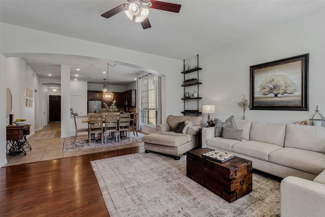 living room featuring ceiling fan and light hardwood / wood-style flooring