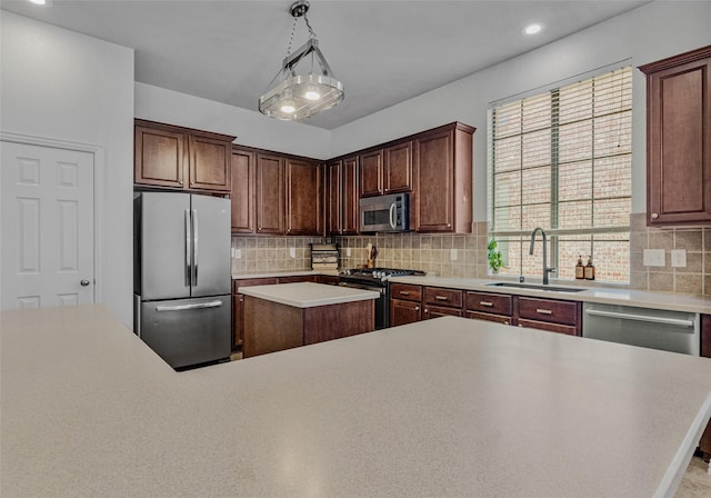 kitchen featuring a center island, sink, hanging light fixtures, decorative backsplash, and stainless steel appliances