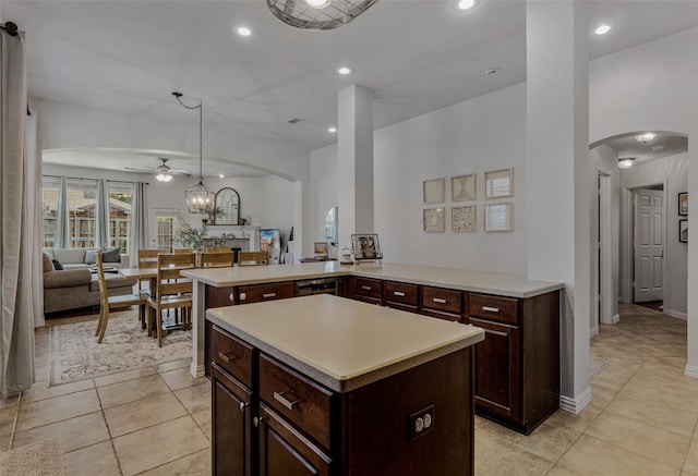 kitchen with kitchen peninsula, ceiling fan, decorative light fixtures, a center island, and light tile patterned flooring