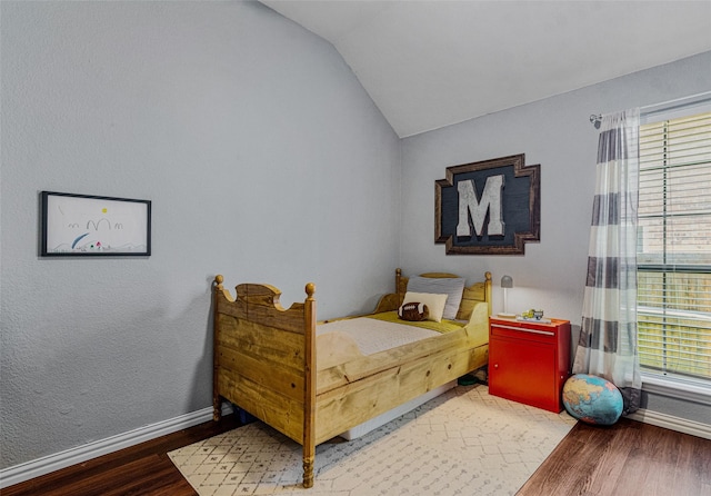 bedroom with hardwood / wood-style floors and lofted ceiling