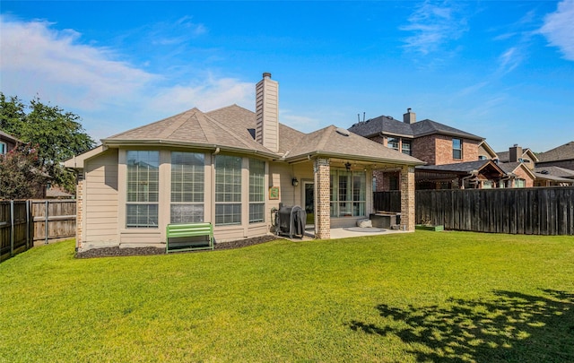 rear view of property with a lawn and a patio area