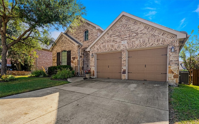 view of front of property featuring a front lawn, cooling unit, and a garage