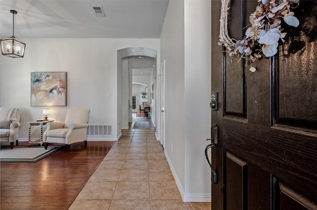 entryway featuring light tile patterned floors and a chandelier