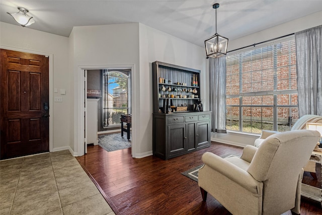 entryway with dark hardwood / wood-style floors and a notable chandelier